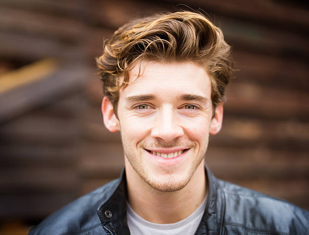 Smiling handsome happy cheerful English male student wearing leather jacket