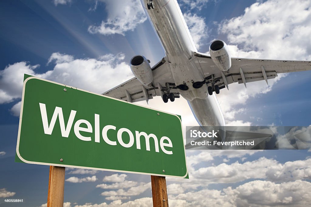 Begrüßung grüne Straßenschild und Flugzeug oben - Lizenzfrei Willkommensgruß Stock-Foto
