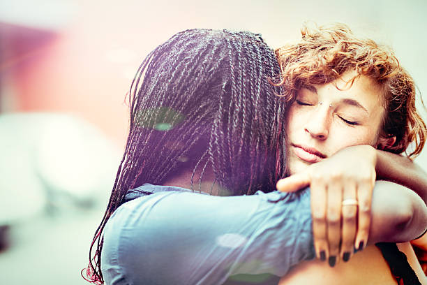 African woman supporting her Caucasian girlfriend stock photo