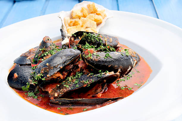 Close up picture of muscles in tomato sauce