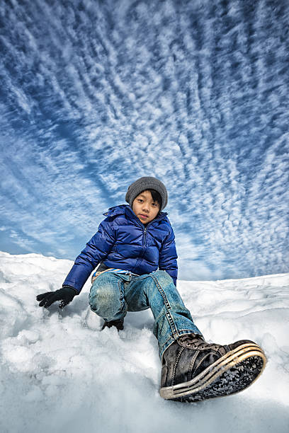 istock Young Asian boy in snow with beautiful sky background 480572131