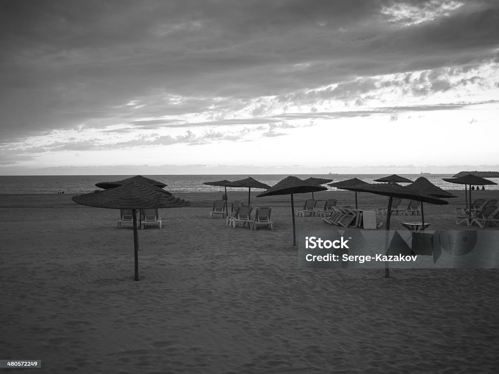 Empty beach with umbrellas Empty beach with umbrellas and clouds Activity Stock Photo