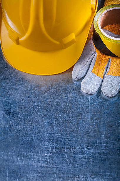istock Safety tape building helmet and protective gloves on scratched m 480572664