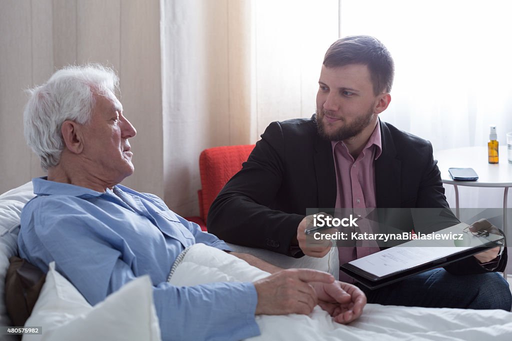 Man and notary Older dying man in hospital talking with his notary 2015 Stock Photo