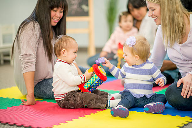 babys und mütter in krippe - togetherness learning playful mother stock-fotos und bilder