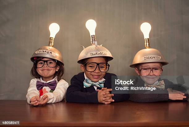 Nerd Hijos Usando Cascos Iluminado Mente De Lectura Foto de stock y más banco de imágenes de Niño