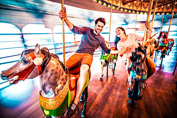 Couple riding merry-go-round in LA Couple in love riding horses on carousel, LA carousel photos stock pictures, royalty-free photos & images