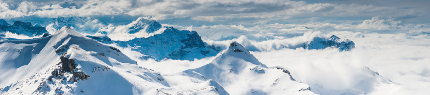 Aerial panoramic vista across the crisp white glaciers, snow capped summits and dramatic rocky ridges of the Alps high in the idyllic mountain wilderness of the Bernese Oberland and Valais, Switzerland. ProPhoto RGB profile for maximum color fidelity and gamut.