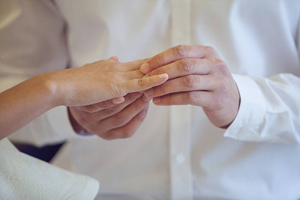 istock Groom Put the Wedding Ring on bride, close up 480585910