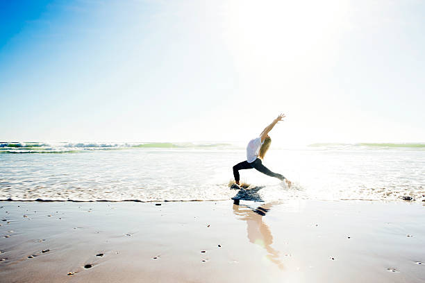 istock A woman practicing yoga on the beach 480587469