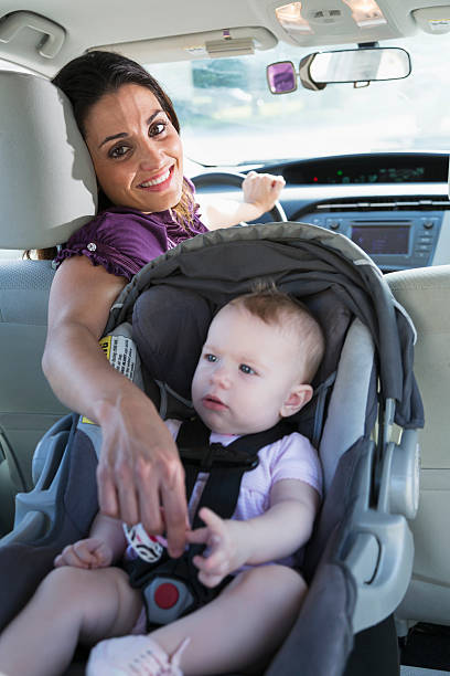 istock Mother with baby in car seat 480592933