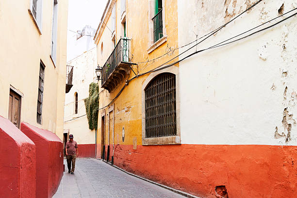 Guanajuato, Mexico- June 21, 2012: An old man walking down a typical alley in the residential area of Guanajuato downtown, a UNESCO world heritage site