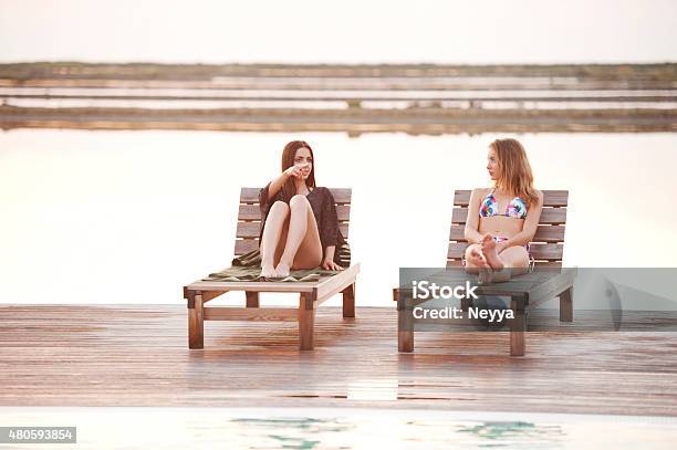 Two Young Women Relaxing At The Swimming Pool Stock Photo - Download Image Now - Outdoors, Sauna, Summer