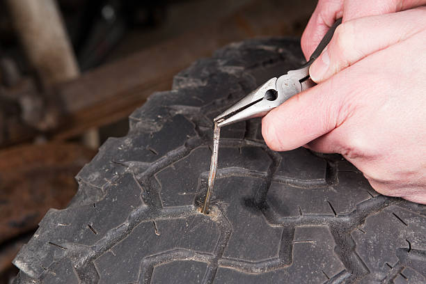 istock Mechanic Removing Nail from Vehicle Tire 480594705