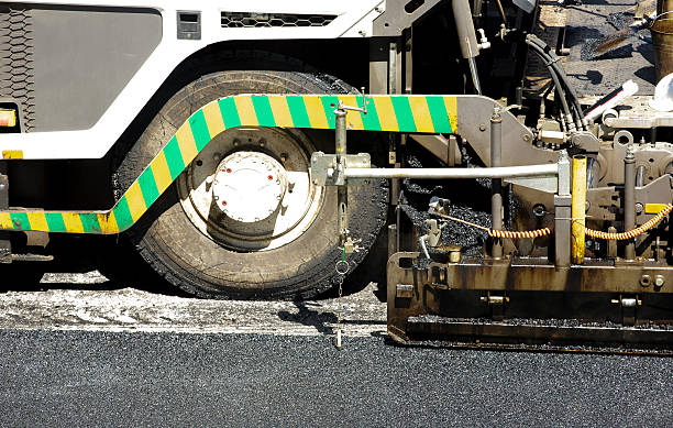 istock Tarmac being laid for a new road surface layer machine 480599690