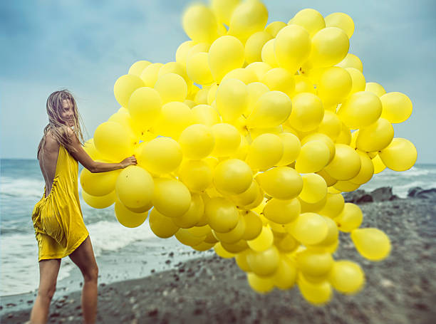девочка с воздушными шарами в желтой зоне - yellow balloon стоковые фото и изображения