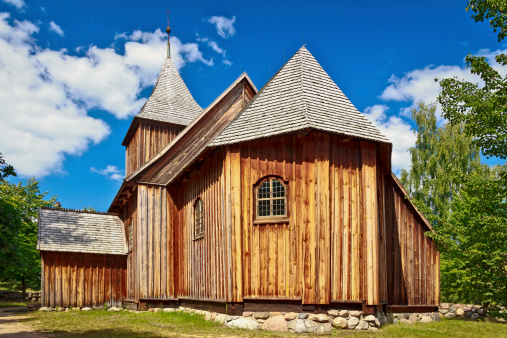 Summer scene with an old wooden rustic Church with wood shingle roof, Wdzydze Kiszewskie in Kaszuby, Poland