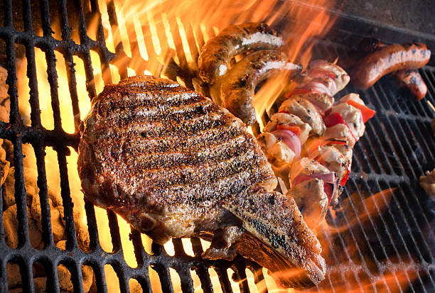 istock Huge Rib Eye Steak with Shish Kebabs, Brats on Grill 480600402
