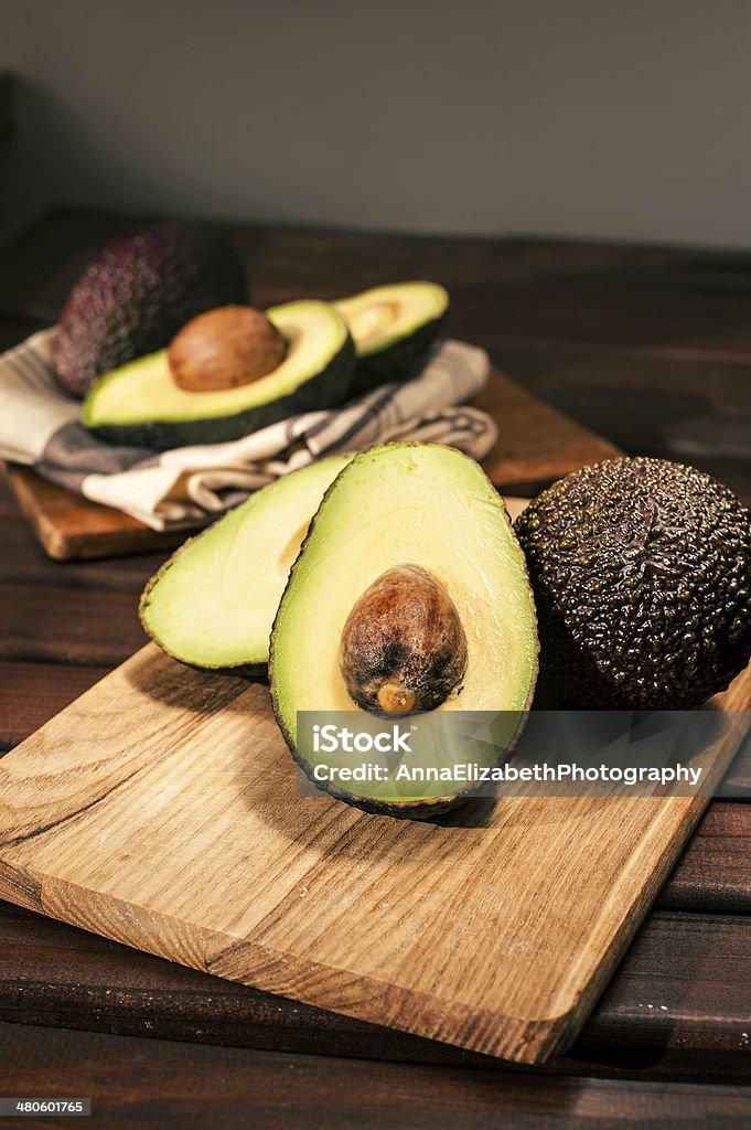 Reife um die Hälfte geschrumpft avocado auf Holz Schneidebrett.  Nahaufnahme. - Lizenzfrei Abnehmen Stock-Foto