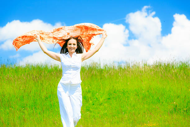 woman on green meadow, holding colorful scarf