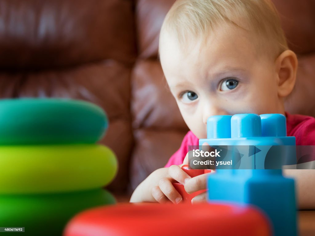 play with toys 5 Portrait of a one year-old child hiding behind toys. 12-17 Months Stock Photo