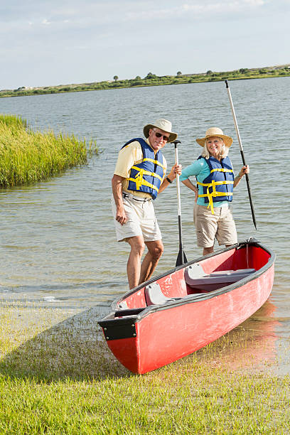 istock Senior couple standing beside canoe 480612803