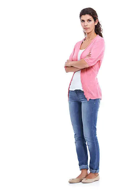 A full length portrait of a serious brunette isolated on white with her arms folded