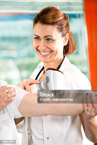 Senior Woman Receiving Home Therapy Stock Photo - Download Image Now - Physical Therapy, Preventive Healthcare, 50-59 Years