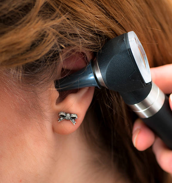 istock doctor checking patient's ear with otoscope 480614732