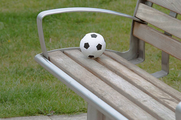 Football on a park bench stock photo