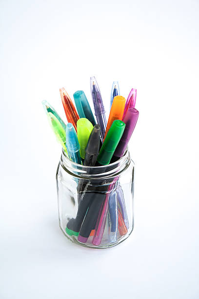 Colourful pens in a glass jar