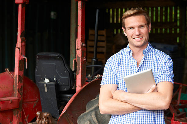 istock Portrait Of Farmer With Old Fashioned Tractor And Digital Tablet 480621442