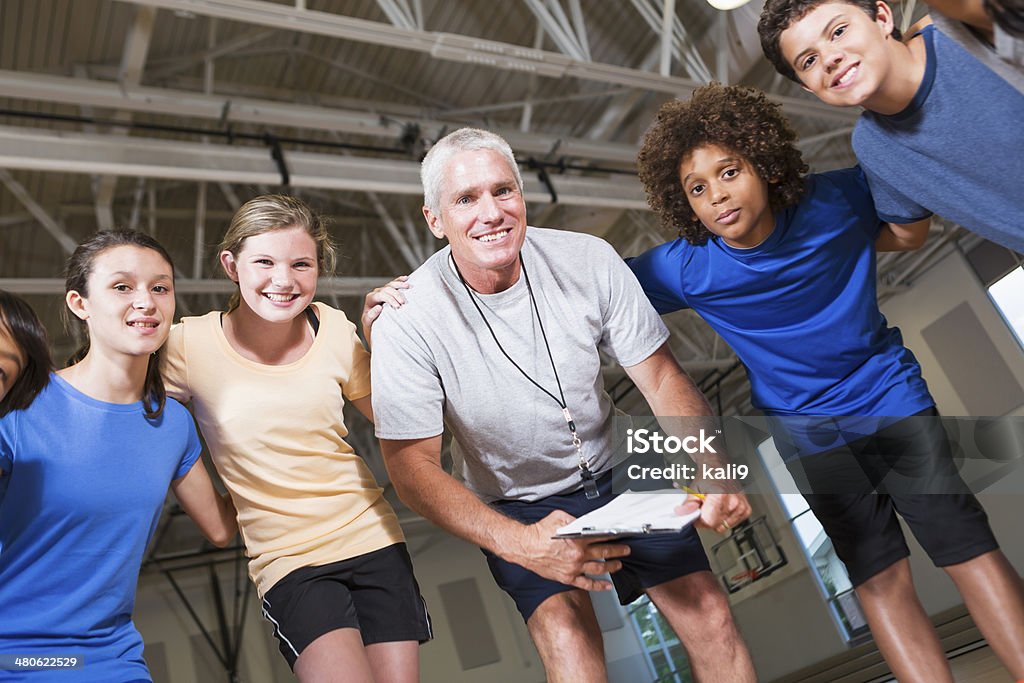 Group of children with coach in school gym Multi-ethnic group of children with coach in school gym. Coach Stock Photo