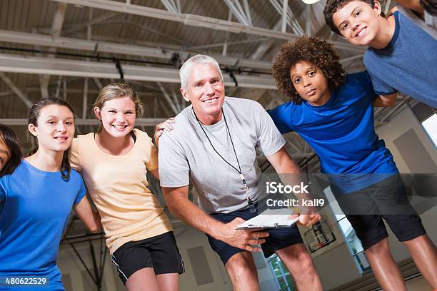 Group Of Children With Coach In School Gym Stock Photo - Download Image Now - Coach, 12-13 Years, 14-15 Years