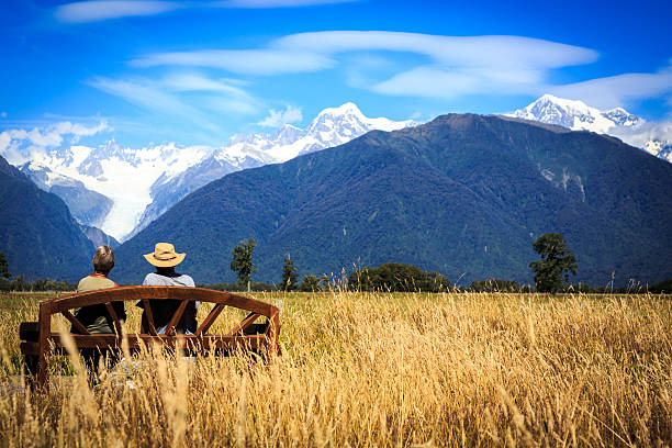 Senior Couple Sitting on Bench in Field, New Zealand