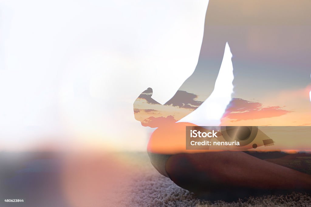 Double exposure of young woman  practicing yoga in nature Double exposure of young woman  silhouette practicing yoga Mindfulness Stock Photo