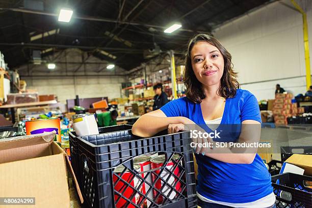 Young Mixedrace Woman Volunteering In Food Bank Warehouse Stock Photo - Download Image Now