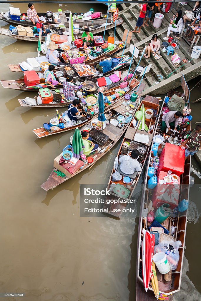 Longtail boat with food market Samutsakorn, Thailand - July 14, 2013: Village and market along a river with Longtail boat with food and souvenir for sale in  Amphawa floating market.  Activity of interest for tourists is take a boat visit the market along the river. And eat thai food from a merchant ship food to be found along the river in the market here. 2015 Stock Photo