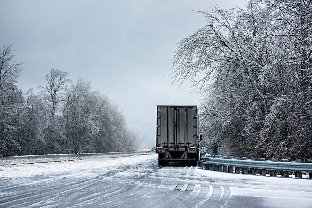 Winter Trucking. A semi truck parked on the side of a freeway during a winter ice storm. truck rain stock pictures, royalty-free photos & images