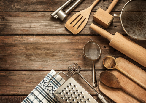 Rural kitchen utensils on vintage planked wood table from above - rustic background with free text space.
