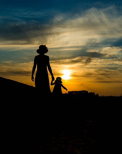 mother and daughter strolling at sunset