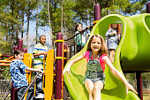 Elementary children play at school recess or park on playground.