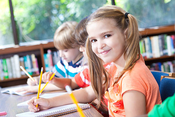 istock Cute little girl in class with classmates 480634679