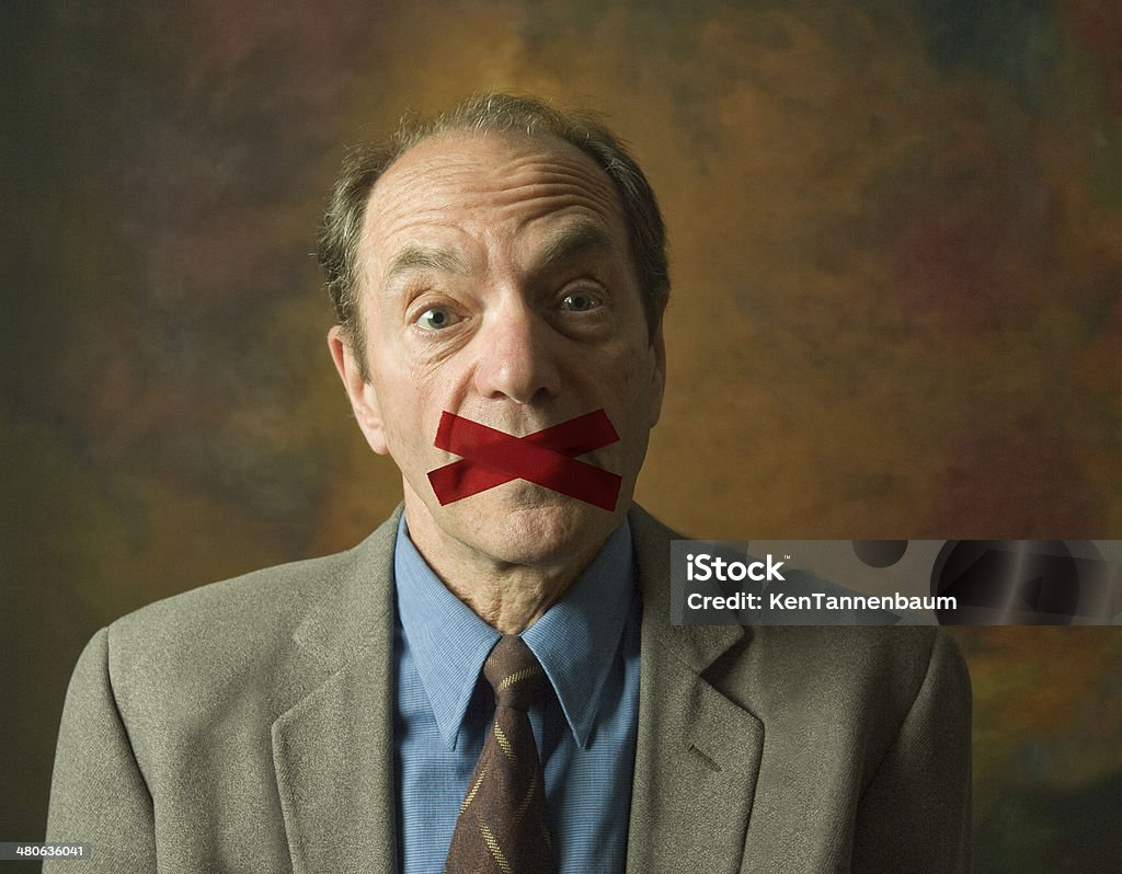 man with tape across mouth portrait of surprised man with mouth taped shut Adhesive Tape Stock Photo