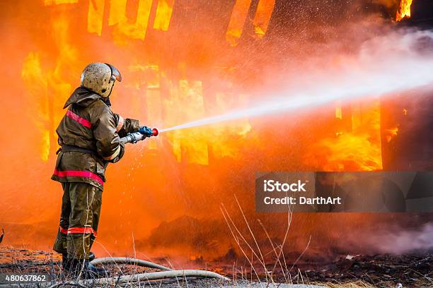 Fireman Extinguishes A Fire Stock Photo - Download Image Now - Fire - Natural Phenomenon, Firefighter, Building Exterior
