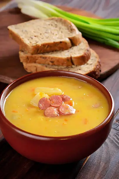 Pea soup in ceramic bowl on wooden table