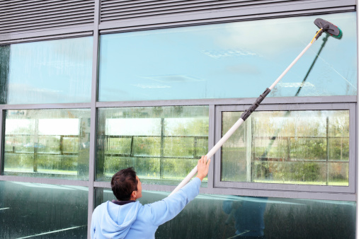 Window cleaner using the water fed pole system, also called reach and wash.