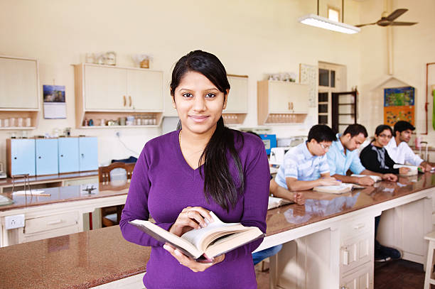 Female engineer writes on whiteboard while student looking