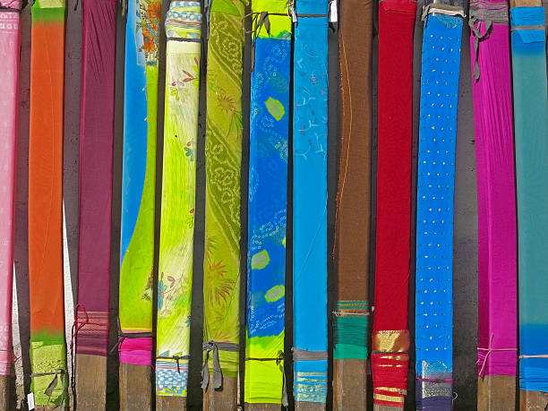 Saris winded up on wooden blocks and kept for drying after coloring process. Pune, Maharashtra, India
