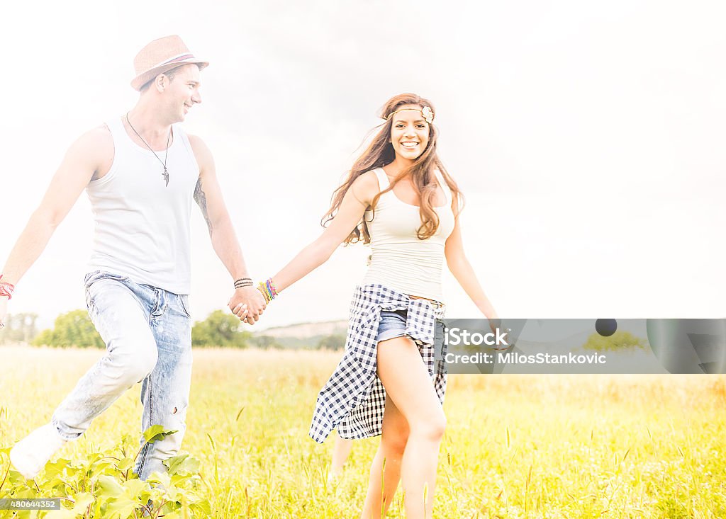 Happy smile hipster couple in field Happy smile hipster couple having fun outdoors 2015 Stock Photo